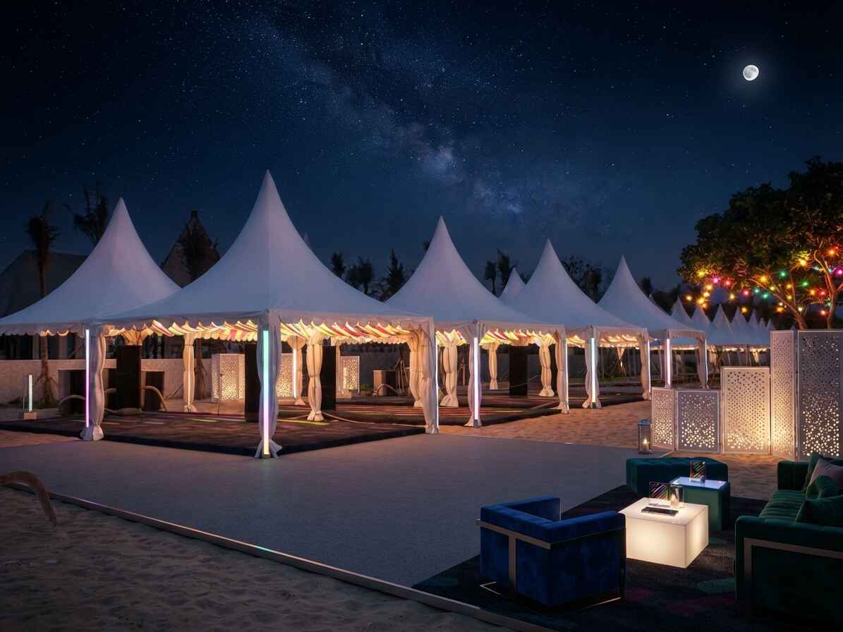 Row of white pagoda tents set up on a sandy beach venue