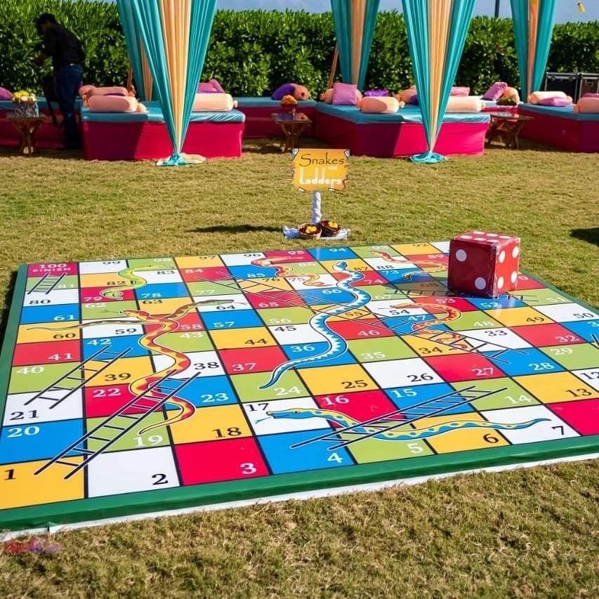 Giant snakes and ladders board game set up on the lawn