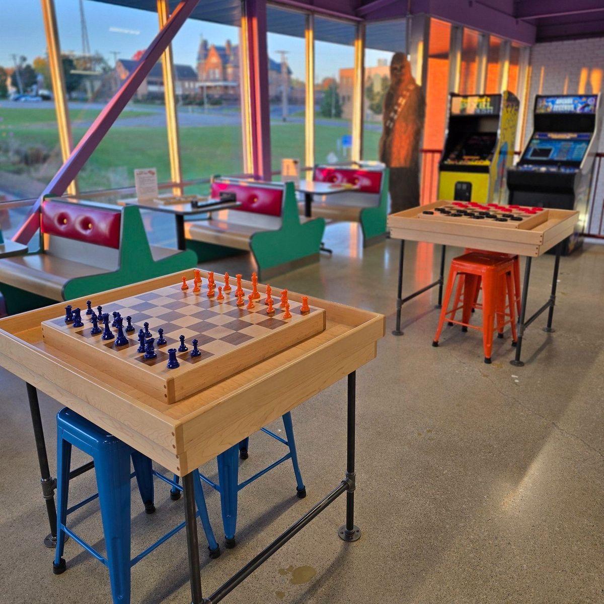 Retro-themed arcade game room with chess, checkers, and vintage arcade machines