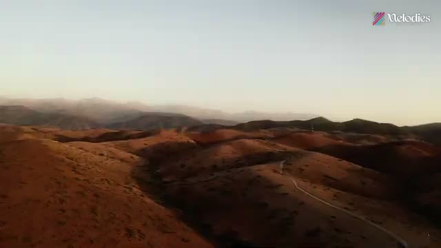 Aerial view of desert mountains at golden hour, from the Melodies showreel