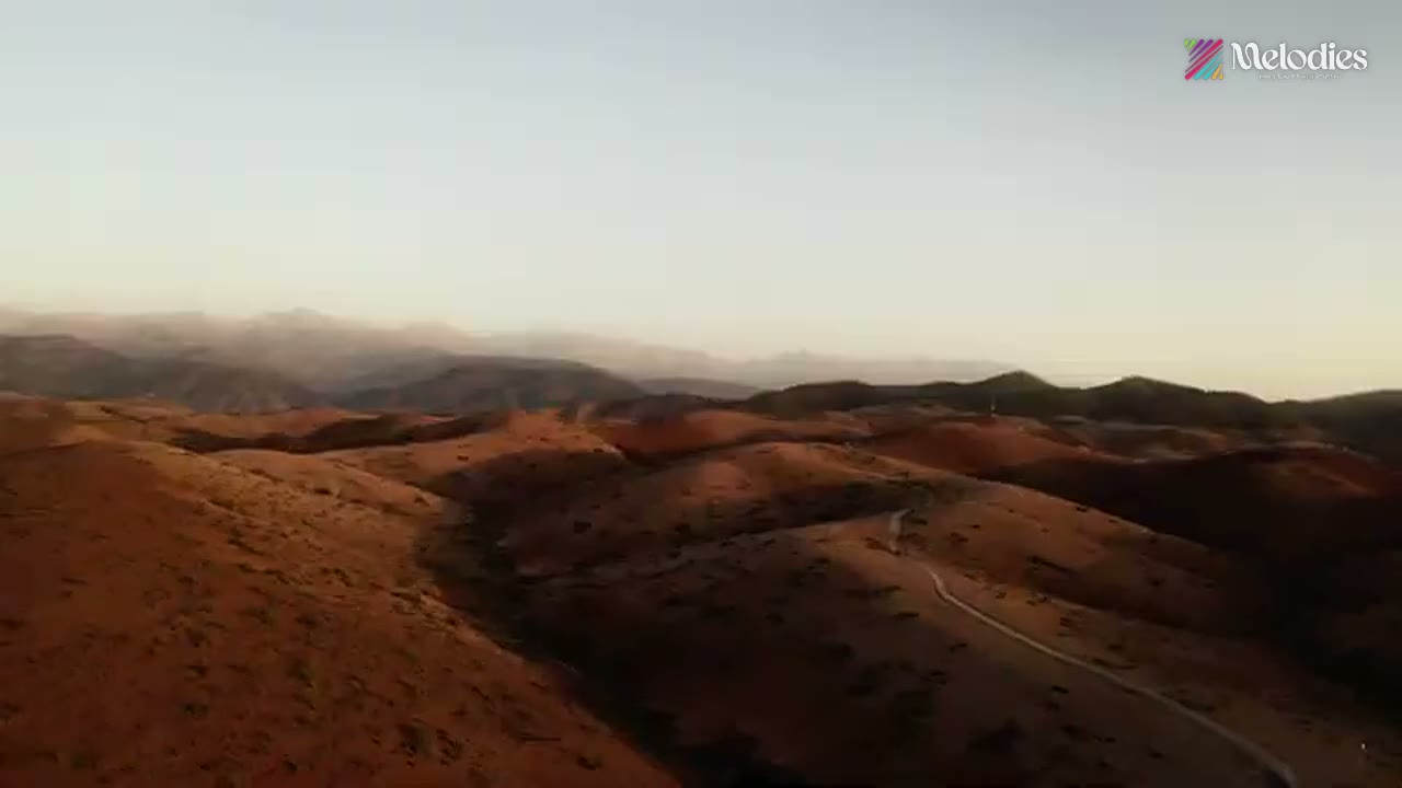 Aerial view of desert mountains at golden hour, from the Melodies showreel